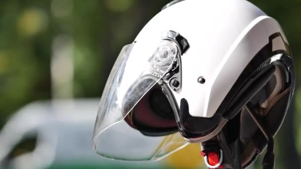Casco de moto blanco en una moto estacionada junto a la carretera. Protector conductor de bicicleta — Vídeo de stock