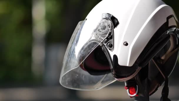 Casco de moto blanco en una moto estacionada junto a la carretera. Protector conductor de bicicleta — Vídeos de Stock