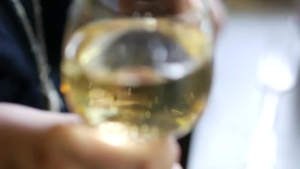 En kvinnlig hand håller ett glas champagne. Damen skålar för semestern — Stockvideo