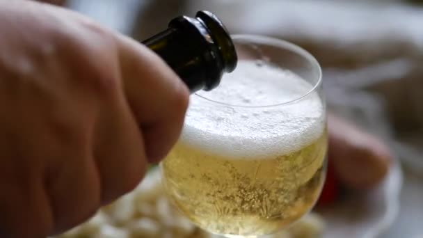Champagne wordt uit de fles in glas gegoten. Bubbels en schuim stijgen in drinkglas — Stockvideo