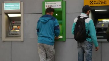 Gençler PrivatBank ve Raiffeisen Bankası 'nın ATM' lerinin önünde duruyorlar. İnsanlar para alır.