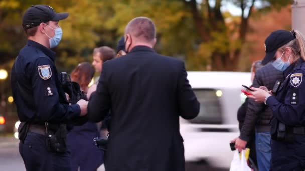 Politieagenten praten met mensen in de straat. Patrouille agenten communiceren met slachtoffers — Stockvideo