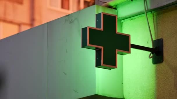 夕暮れ時に建物に緑の点灯薬局の看板。ライトアップされた住宅建築 — ストック動画