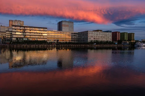 Weergave van moderne gebouwen in de buurt van het water tijdens zonsondergang — Stockfoto