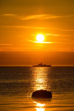 Günbatımı denizde bir gemi ile muhteşem manzara.