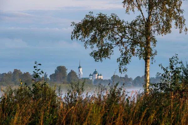 夜明けに霧の朝に川を渡る教会の眺め — ストック写真