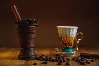 Kil Kupası Kahve çekirdekleri ve ahşap bir masa üzerine tarçın ile.