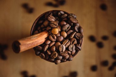 Kil Kupası Kahve çekirdekleri ve ahşap bir masa üzerine tarçın ile.