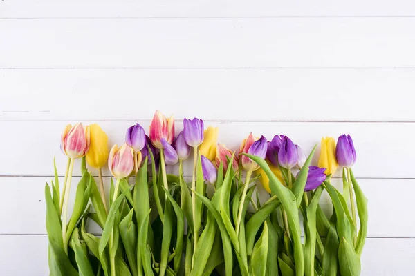 Kolorowe tulipany na drewnianym stole. Widok z góry z miejsca kopii — Zdjęcie stockowe