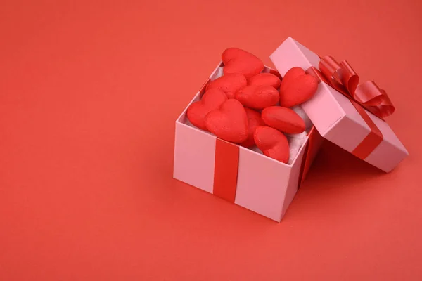 Coffret cadeau. boîte rose sur un fond rouge avec des cœurs rouges. Contexte de la Saint-Valentin . — Photo