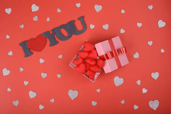 Подарочная коробка. розовая коробка на красном фоне с красными и серебряными сердцами. Предпосылки ко Дню Святого Валентина — стоковое фото