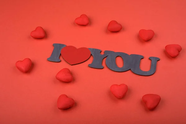 Ystävänpäivä. Punaiset sydämet punaisella taustalla ja teksti Rakastan sinua, ylhäältä — kuvapankkivalokuva