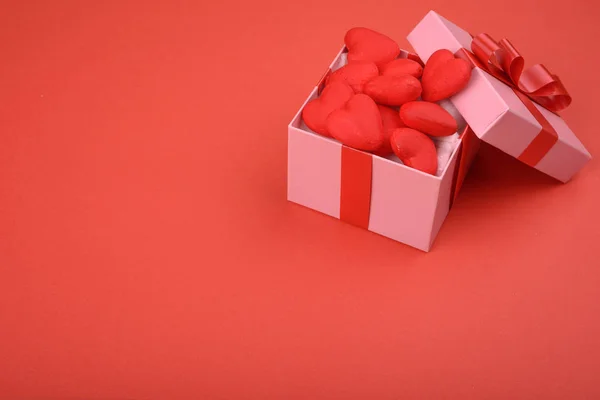 Coffret cadeau. Boîte rose sur fond rouge avec cœurs rouges et espace pour le texte. Contexte de la Saint-Valentin . — Photo