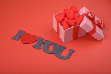 Hediye kutusu ve yazıt kırmızı zemin üzerine seviyorum seni. Sevgililer günü, anneler günü, tatil