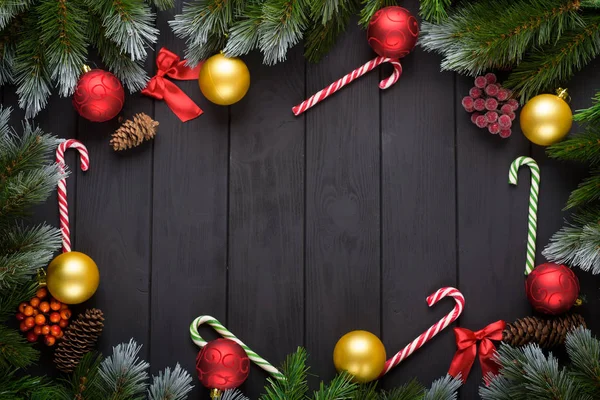 Різдво або новий рік прикраса фону: ялинці гілки, барвисті кульки, шоколадна цукерка на чорному фоні. Вид зверху з копіюванням простору. Фальт лежав — стокове фото