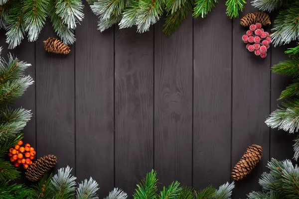 Natale o Capodanno decorazione sfondo: rami di abete, palline colorate, canna da zucchero su sfondo nero. Vista dall'alto con spazio di copia. Falt lay — Foto Stock