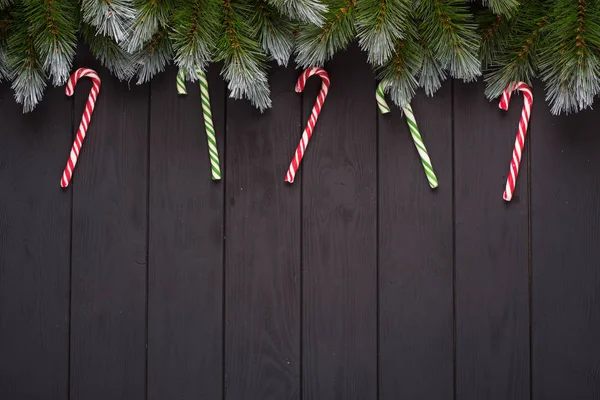 Boże Narodzenie lub nowy rok ozdoba tło: jodła gałęzie, kolorowe kulki, trzciny cukrowej na czarnym tle. Widok z góry z przestrzenią kopiowania. Falt leżał — Zdjęcie stockowe