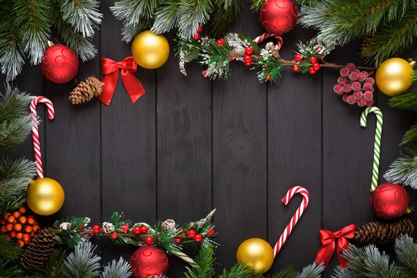 Natale o Capodanno decorazione sfondo: rami di abete, palline colorate, canna da zucchero su sfondo nero. Vista dall'alto con spazio di copia. Falt lay — Foto Stock