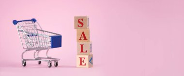 Kırmızı sözcüğün satışı, boş bir süpermarket arabasıyla ahşap küplerden yapılmıştı. Pembe arka planda ürünler için, yazı için yer vardı. Kara Cuma günü süpermarkette veya çevrimiçi mağazada ürün satma kavramı