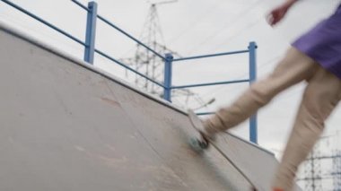 Profesyonel patenci genç, kaykay parkında ekstrem sporlarla meşgul. Sarışın kaykaycı yaz bulutlu havalarda bir aşağı bir yukarı atlayıp zıplayarak numaralar yapıyor..