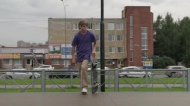 Profesyonel patenci genç, kaykaycı, kaykaycı, genç sarışın çocuk kaykaya biniyor ve yaz bulutlu havalarda çok yüksekten yere atlıyor..