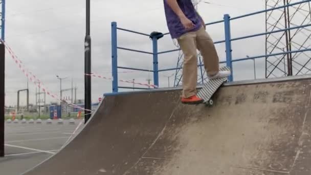 Profi-Skater-Teenager treibt Extremsport im Skatepark. Junge blonde Skateboarderin fährt in Grubenrampe auf und ab und macht bei sommerlich bewölktem Wetter Sprünge und Tricks hoch oben in der Luft. — Stockvideo