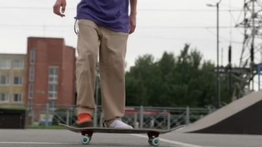 Genç kaykaycı kaykaycı 360 kickflip topuklu takla atarak, ollie, kaykay parkında, bulutlu havada. Paten parkında profesyonel patenci numaralar yapıyor.