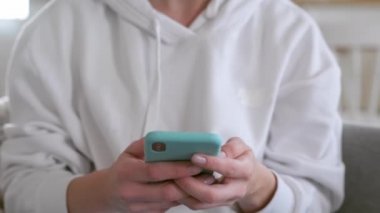 Telefon kullanan bir kız, internetteki sosyal ağlarda geziniyor. Evdeki kadın kanepeye uzanmış yeşil ekran ekranı olan akıllı telefon kullanıyor, hareketler yapıyor, araklıyor. St. Petersburg, Rusya, Aug, 2020