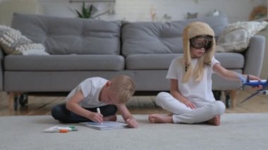 Kız ve erkek kardeş birlikte mutlular. Odada birlikte oynuyorlar, yerde oturuyorlar. Erkek kardeş renkli kalemlerle resim çizer, kız kardeş oyuncak yolcu uçağıyla oynar ve uçak pilotu olmayı hayal eder..