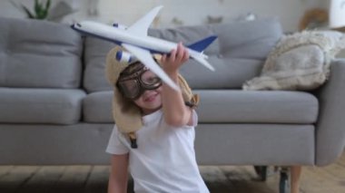 Küçük mutlu çocuk, gözlüklü ve pilot şapkalı beyaz yolcu uçağıyla oynuyor. Gün boyunca bir apartmanın zemininde oturuyor. Çocuk uçmayı öğrenmek için hayal kurar. Seyahat ve macera kavramı.