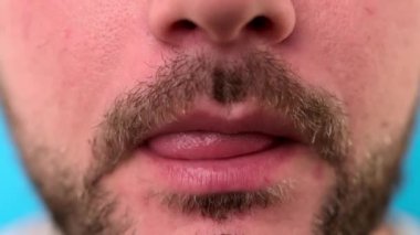 Saman yoluyla soda içen traşsız bir adamın yakın çekimi. Çocuk susuzluğunu giderir ve bardaktan samana soda içer..