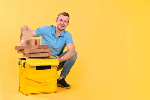 Young Caucasian Food Delivery Guy Blue Uniform Sitting Next Yellow — Stock Photo, Image