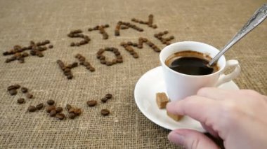 Bir kupa kahve, kahve çekirdeği ve kelimeler evde kalır, koronavirüs konsepti, kişisel karantina konsepti.