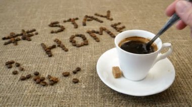 Bir kupa kahve, kahve çekirdeği ve kelimeler evde kalır, koronavirüs konsepti, kişisel karantina konsepti.