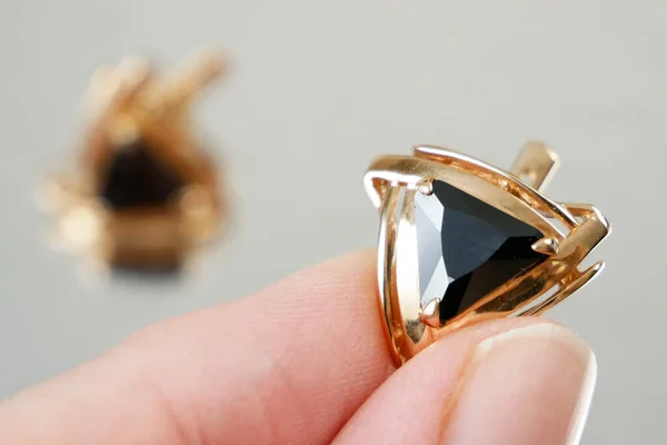Hand Nimmt Goldenen Ohrring Mit Schwarzem Stein Juwelier Betrachtet Schmuck — Stockfoto