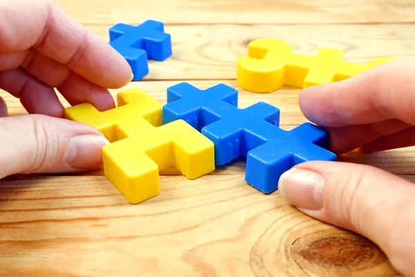 mental health, brain health, adult person plays with yellow and blue puzzzles, alzheimer illness test