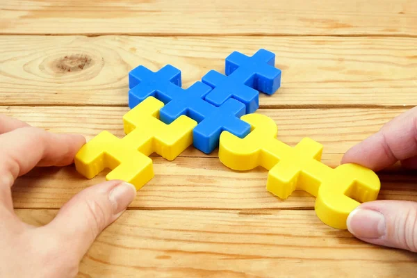 mental health, brain health, adult person plays with yellow and blue puzzzles, alzheimer illness test