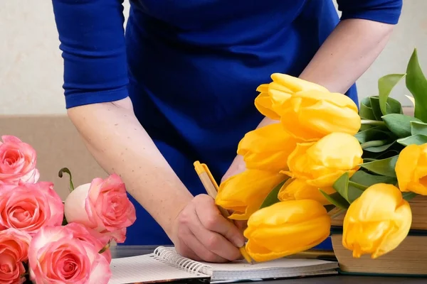Florist workplace, florist makes a bouquet with roses, tulips and french macaroni, small business, florist online, order and flower delivery