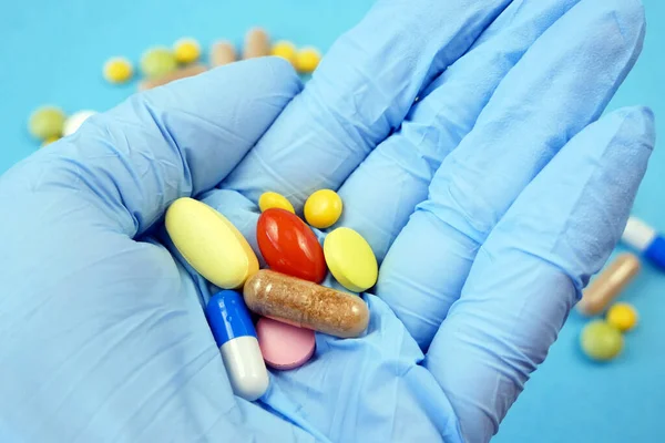 hand takes tablets, many pills in blisters and capsules background, Pharmaceutical medicament. Coronavirus treatment concept
