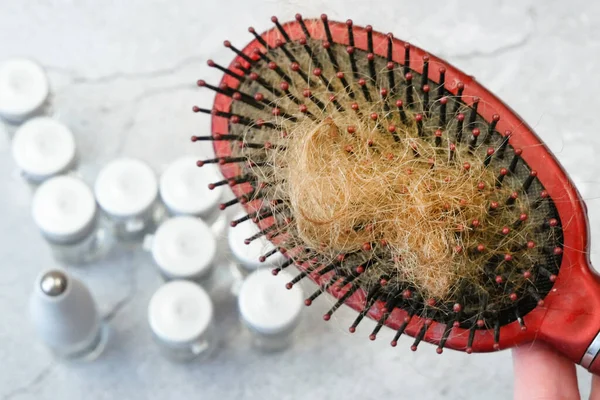 脱毛の問題 ヘアブラシ ヘアブン付きボトル 別の治療法薬瓶と櫛を灰色の背景に — ストック写真