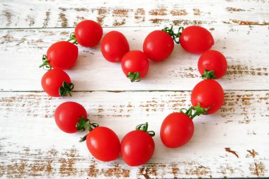Taze kırmızı lezzetli domatesler kalpte kiraz şeklinde ahşap bir arka planda