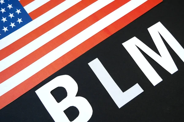 black lives matter concept, letters BLM and american flag  on black background
