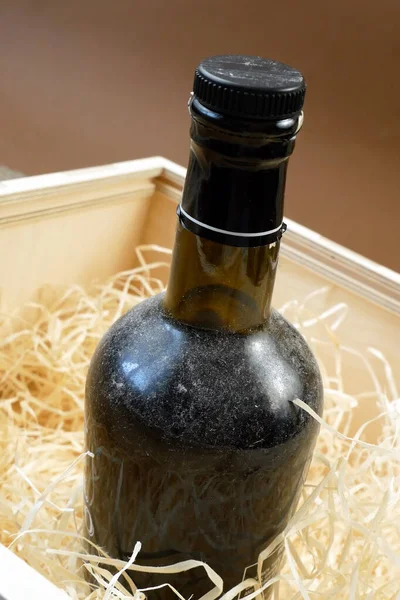 glass and bottle of expensive elite wine in a wooden box with shavings, wine tasting, online order and delivery wine in coronavirus time, internet wine shops concept