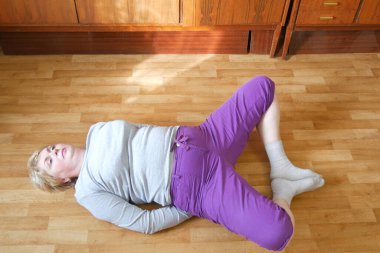 kilolu orta yaşlı bir kadın apartman dairesinde spor yapıyor. Coronavirus salgını sırasında uzaktan eğitim alıyor.