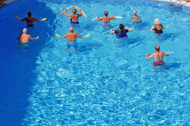 İnsanlar bir tatil köyünde yüzme havuzunda müktesebatını, Coronavirus salgınından sonra turizmi yapıyorlar.