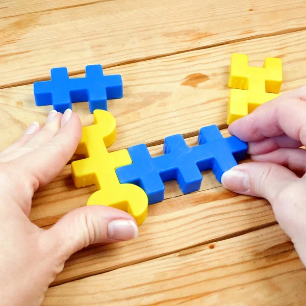 mental health, brain health, adult person plays with yellow and blue puzzzles, alzheimer illness test