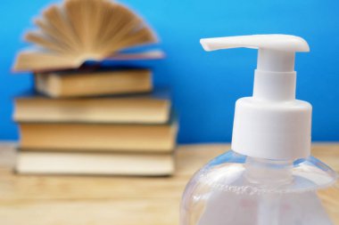 Okula Dönüş Coronavirus Covid-19, kitap yığını, dezenfektan ve tıbbi maske.