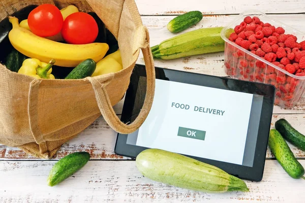 Organic Vegetables and fruits in cotton bag and mobile phone with copy space, online market, green grocery delivery at home concept, buy online concept