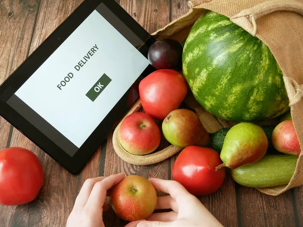 Organic Vegetables and fruits in cotton bag and tablet pc with copy space, online market, green grocery delivery at home concept