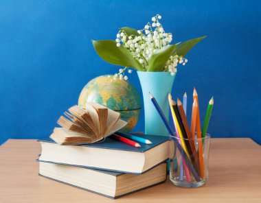 Dünya Öğretmenler Günü konsepti. Çiçekler demet, harita, küre ve kitaplar yığın